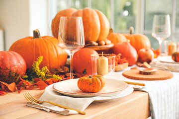 Beautiful table setting with pumpkins in dining room