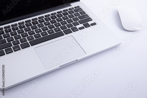 new modern laptop keyboard with computer mouse isolated on white background, close view . High quality photo