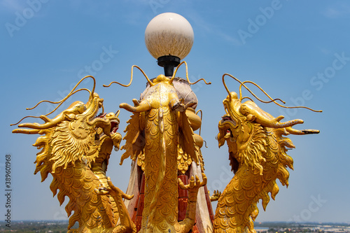 Golden Chinese dragon statues decorate the lamp on the rooftop, Wat Samphran Dragon Temple, Nakhon Pathom, Thailand. photo