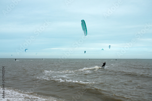 Man kitesurfing on the North Sea in a black wetsuit