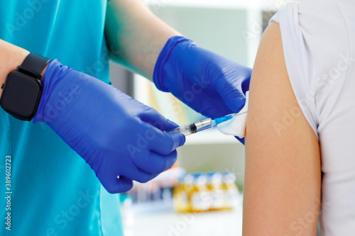 Doctor hands making a vaccination in the shoulder of patient