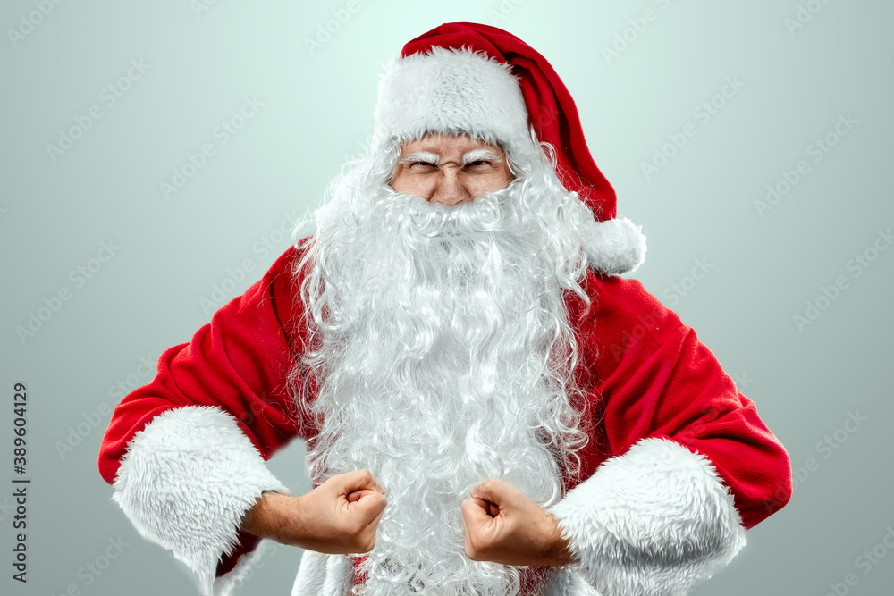 Portrait of a cheerful Santa Claus in a red suit close-up, light background. Concept for christmas eve, vacation, holiday banner, new year. Portrait of a cheerful Santa Claus in a red suit close-up, light background. Concept for christmas eve, vacation, holiday banner, new year.
