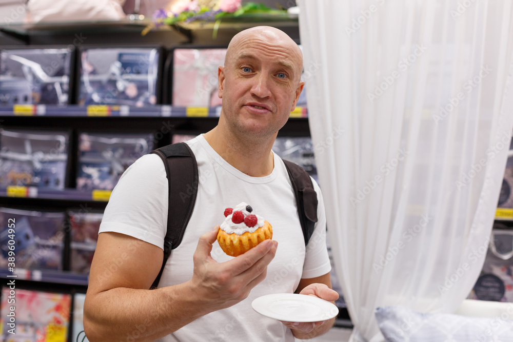 Happy man in the store with a cake in his hand