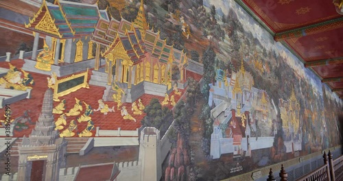 Thai mural paintings at Wat Phra Kaew in Bangkok, Thailand. Scenes of Ramayana anciet Indian story are painted in the gallery along the temple's wall. photo