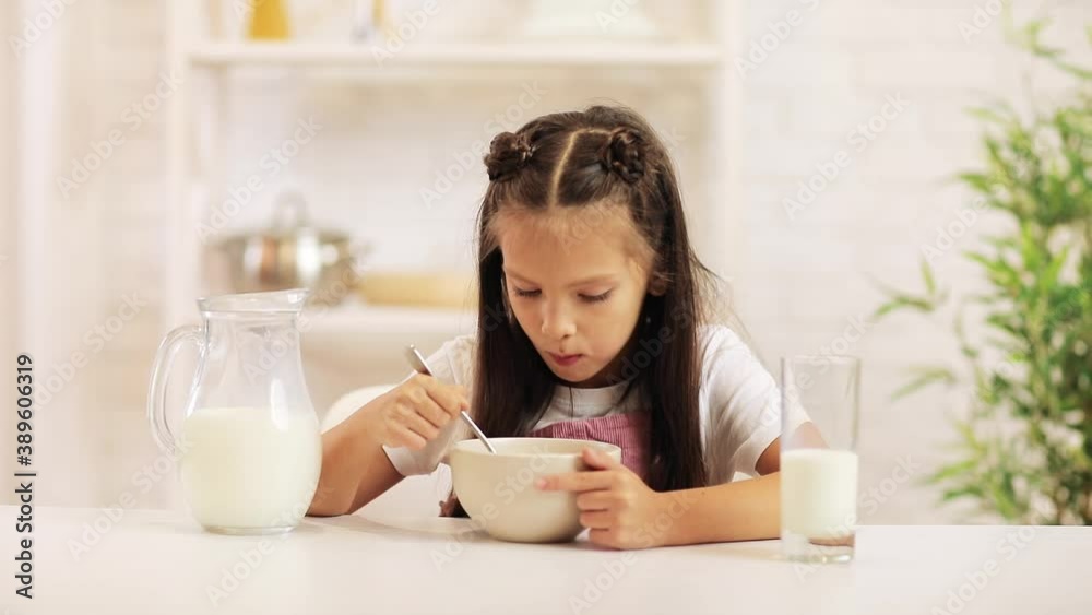 cute little girl eating breakfast: cereal with the milk. healthy breakfast cute little girl eating breakfast: cereal with the milk. healthy breakfast