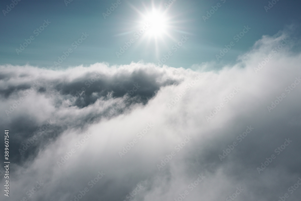 Clouds in the sky with the sun shining upon. Outdoor aerial adventure photography, view while paragliding above the clouds.