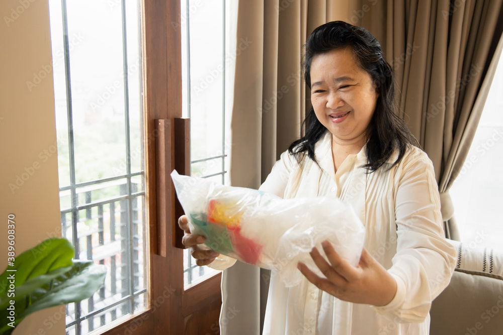 Senior Asian woman collecting used plastic bag for recycling purpose, concept of plastic material recycle, global warming problem, ecology and environment concern Senior Asian woman collecting used plastic bag for recycling purpose, concept of plastic material recycle, global warming problem, ecology and environment concern
