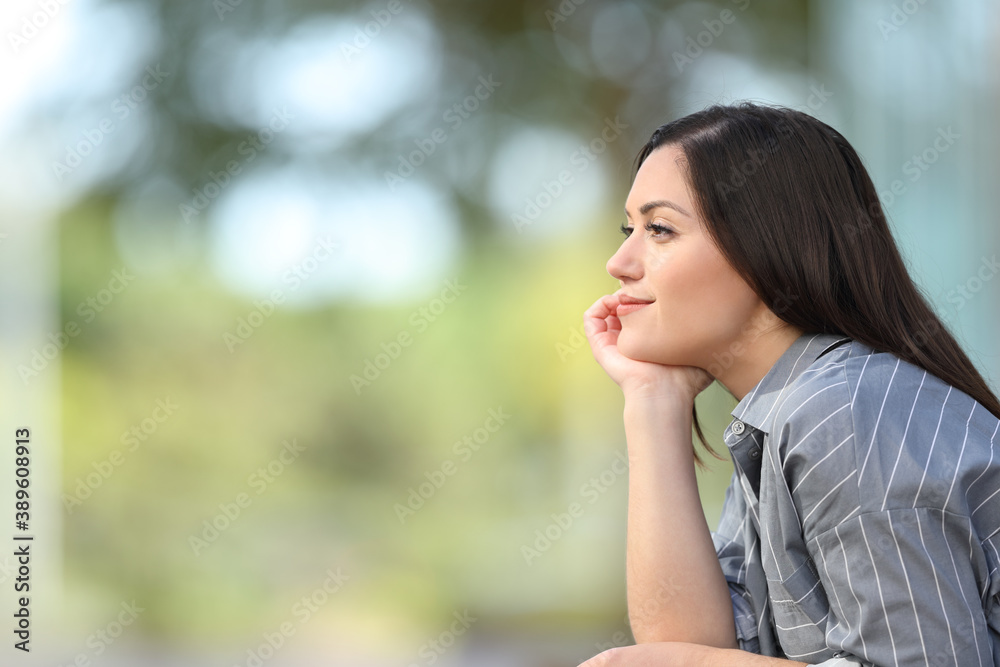Woman meditating looking away in the street