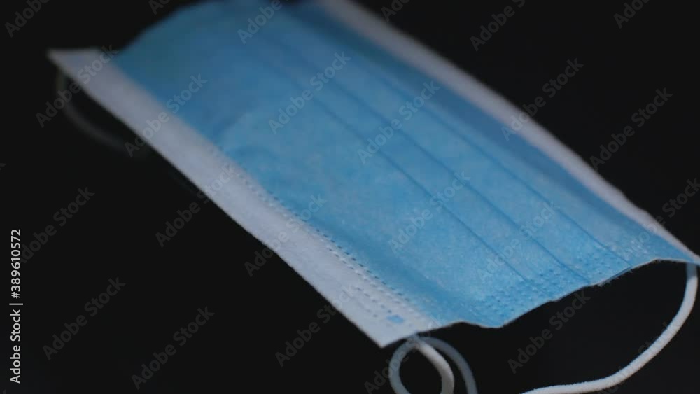 The Medical Mask Rotates in the Dark Black Background. The Medical Mask Rotates in the Dark Black Background.