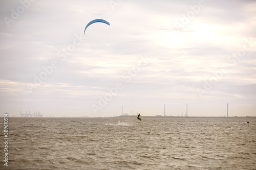 Man kitesurfing on the North Sea in a black wetsuit