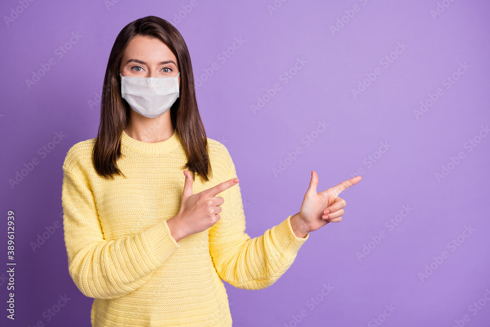 Photo portrait of young woman pointing two fingers at blank space wear safety mask isolated purple colored background Photo portrait of young woman pointing two fingers at blank space wear safety mask isolated purple colored background