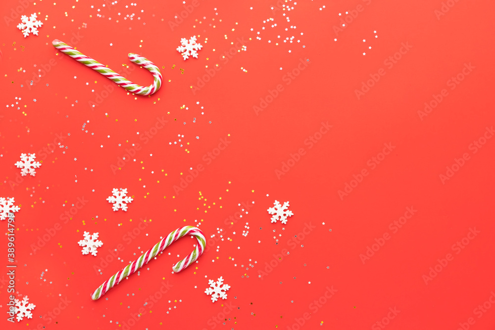 New Year's flat lay. On a red background, star candy, snowflakes and a caramel stick. New Year's flat lay. On a red background, star candy, snowflakes and a caramel stick.