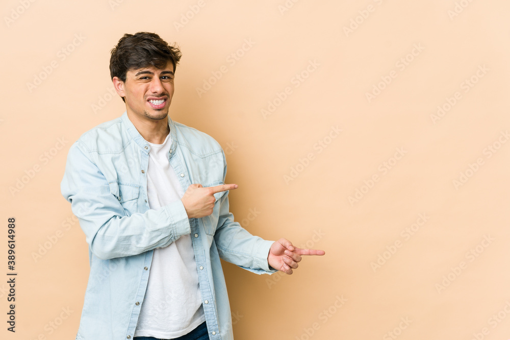 Young cool man shocked pointing with index fingers to a copy space. Young cool man shocked pointing with index fingers to a copy space.