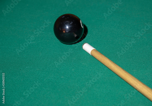 One pool ball and cue on the snooker table.