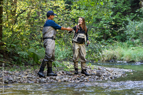 Young woman learning to fly fishing with a profesional guide