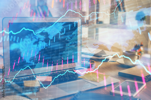 Financial graph colorful drawing and table with computer on background. Multi exposure. Concept of international markets.