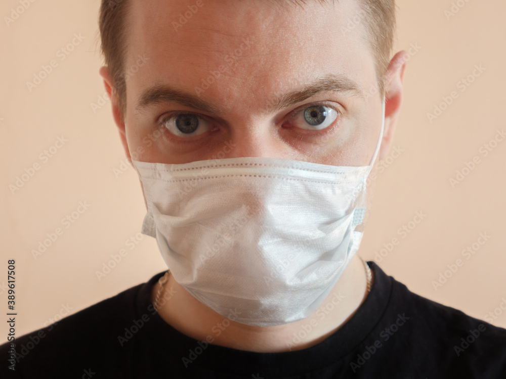 Young man wearing protective medical mask. Selective focus. Young man wearing protective medical mask. Selective focus.