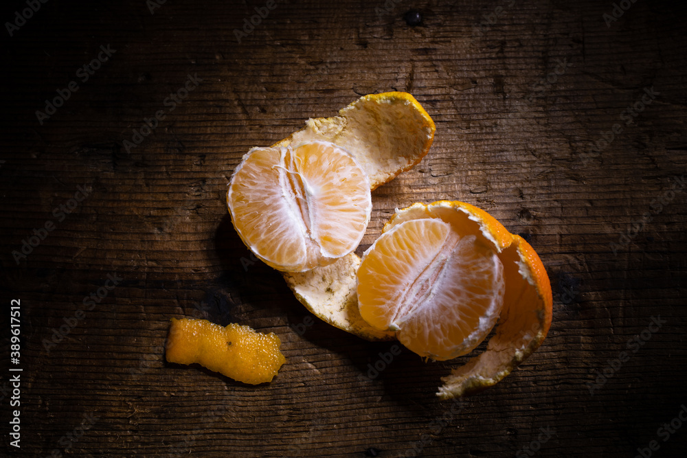 half open clementine with peels on wooden background half open clementine with peels on wooden background