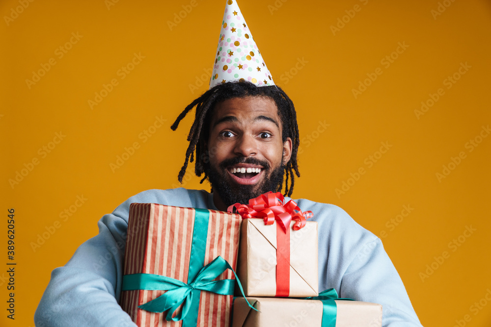 Portrait of an excited young man holding many gifts