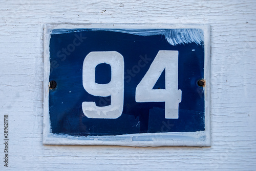 Weathered grunge square metal enameled plate of number of street address with number 98