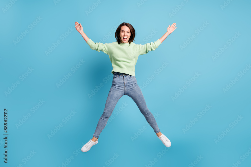 Full length body size photo of funny jumping high like a star girl wearing casual clothes laughing smiling isolated on vibrant blue color background