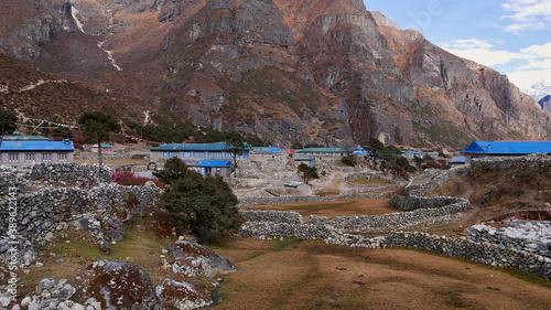 Stone houses with blue painted roofs and meadows surrounded by stone walls in small village Thame, Khumbu, Himalayas, Nepal on the Three Passes Trek.