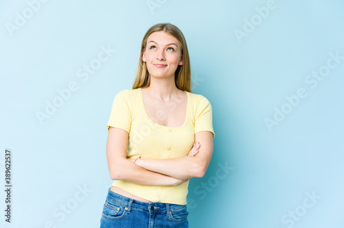 Young blonde woman isolated on blue background tired of a repetitive task.