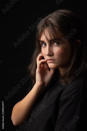 Beautiful portrait of a young girl on a black background
