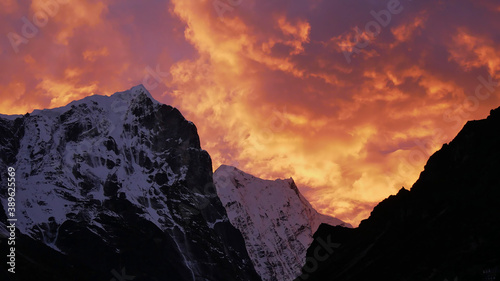 Stunning sunset above ice-capped mountains in the Himalayas near village Thame  Khumbu  Nepal with dramatic colorful sky looking like the flames of a giant fire.