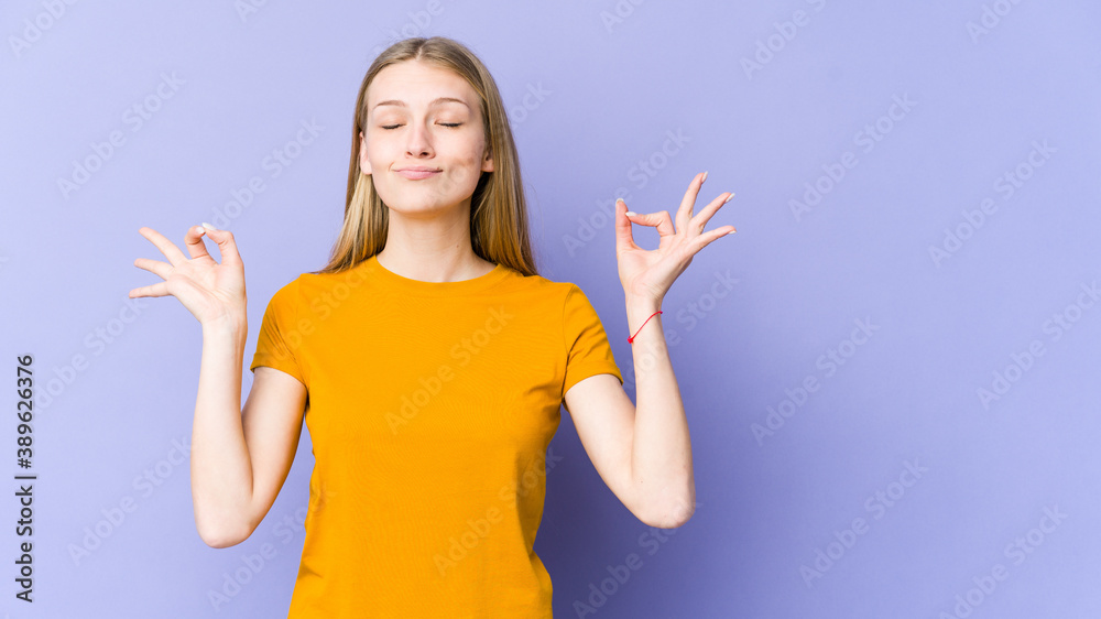 Young blonde woman isolated on purple background relaxes after hard working day, she is performing yoga. Young blonde woman isolated on purple background relaxes after hard working day, she is performing yoga.