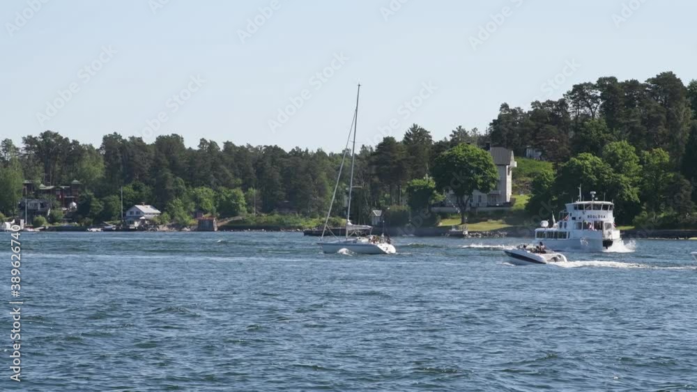 A commuting and varied collection of boats in a narrow inlet to the archipelago town Vaxholm in Stockholm a sunny summer day A commuting and varied collection of boats in a narrow inlet to the archipelago town Vaxholm in Stockholm a sunny summer day