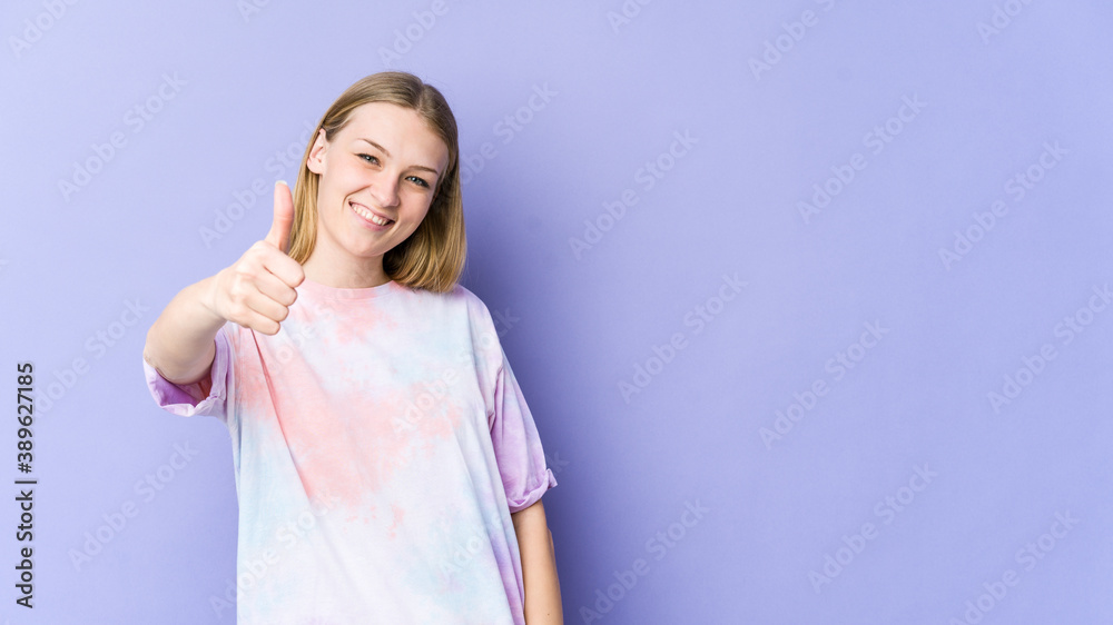 Young blonde woman isolated on purple background smiling and raising thumb up Young blonde woman isolated on purple background smiling and raising thumb up