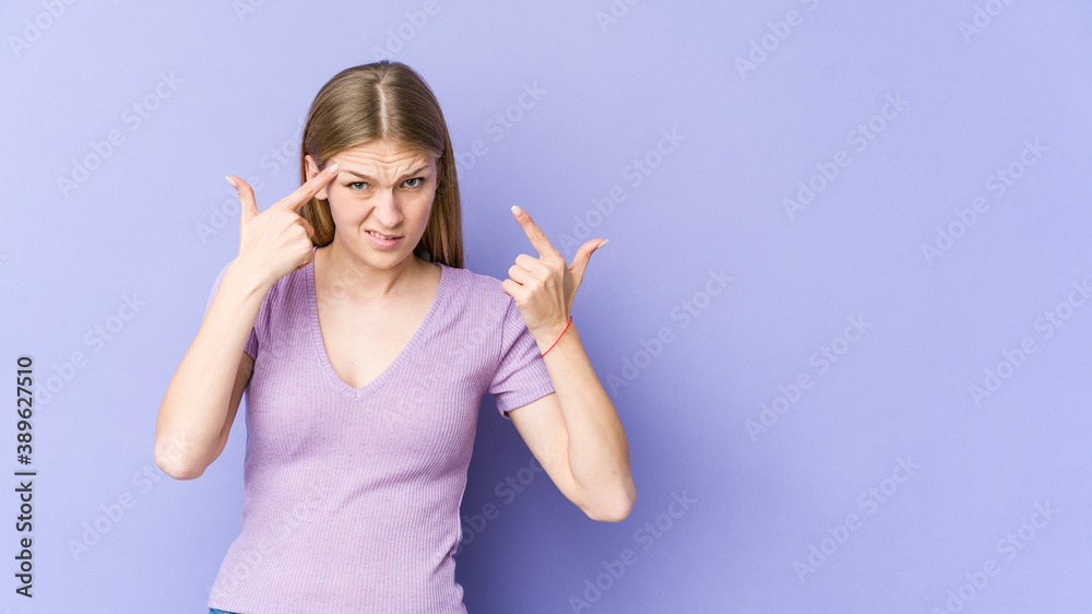 Young blonde woman isolated on purple background showing a disappointment gesture with forefinger. Young blonde woman isolated on purple background showing a disappointment gesture with forefinger.