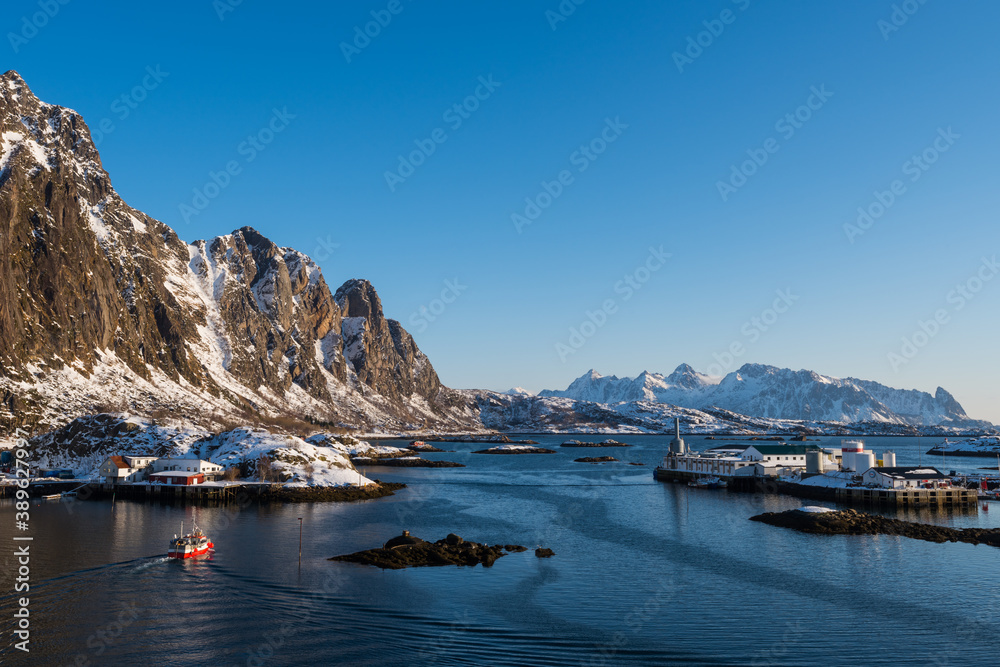 View over the port and winter mountain landscape of Svolvaer on the Lofoten islands in morning sunrise in winter with snow