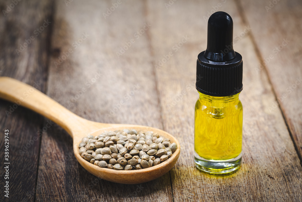 Cannabis seeds and CBD oil cannabis extract, green hemp leaf background, Medical cannabis concept. Cannabis seeds and CBD oil cannabis extract, green hemp leaf background, Medical cannabis concept.