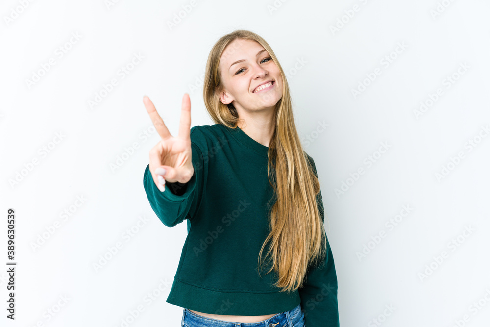 Young blonde woman isolated on white background showing victory sign and smiling broadly. Young blonde woman isolated on white background showing victory sign and smiling broadly.