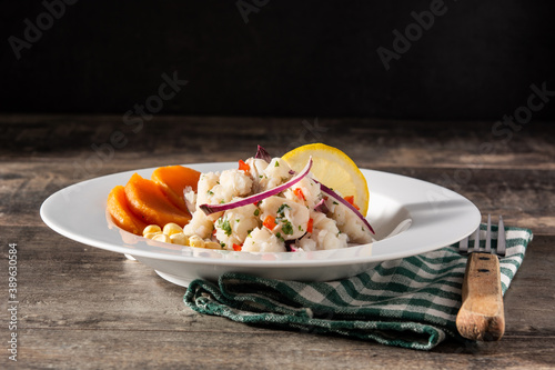 Traditional peruvian ceviche with fish, sweet potato, corn and vegetables on wooden table