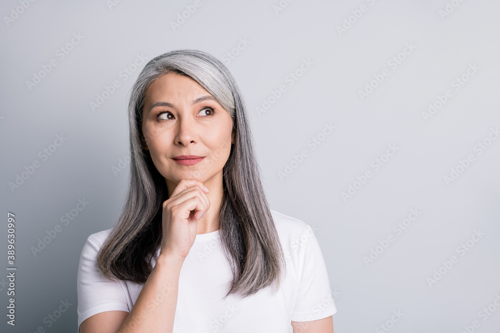 Photo of thoughtful pensioner grandma arm chin look up empty space wear white t-shirt isolated grey color background Photo of thoughtful pensioner grandma arm chin look up empty space wear white t-shirt isolated grey color background