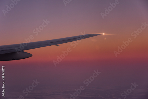 夕焼けの中上昇を続けるB-777-200主翼