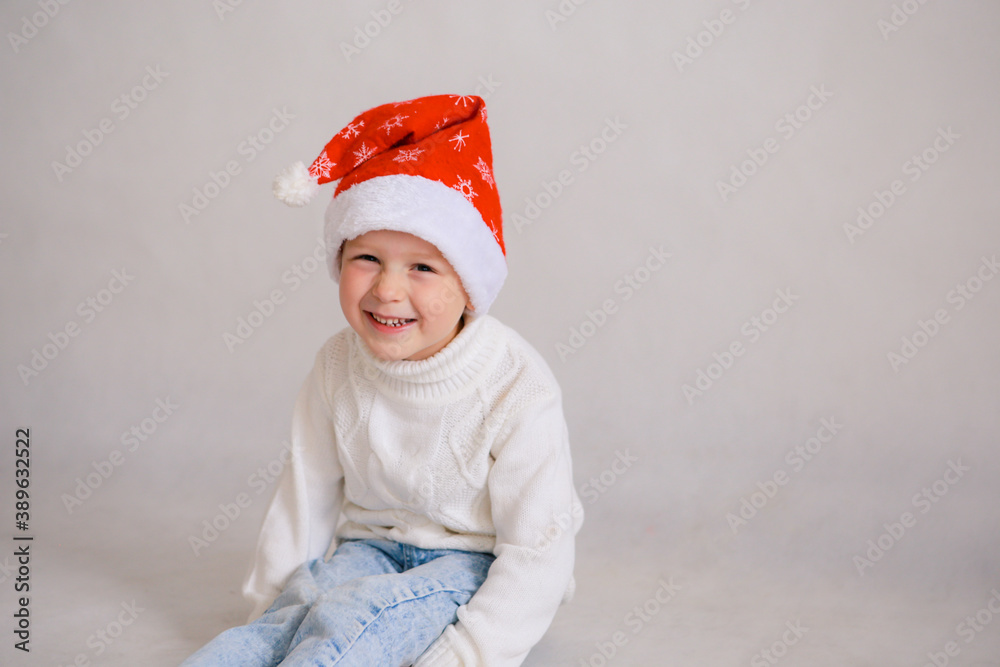 Happy child in Santa red hat. White isolated background. Christmas. Garland Happy child in Santa red hat. White isolated background. Christmas. Garland