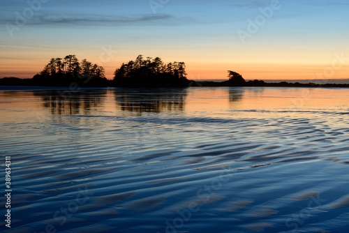 Chesterman Beach surrounded by the sea during the sunset in Tofino, Canada photo
