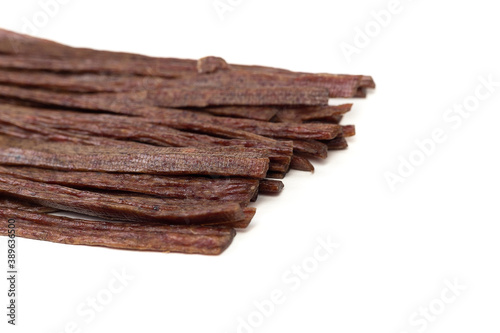Dried beef meat sliced on stick, beer snack isolated on white background