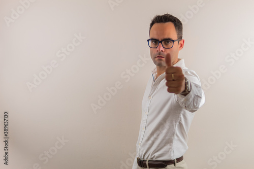man with glasses and white shirt, is with his hand making a like