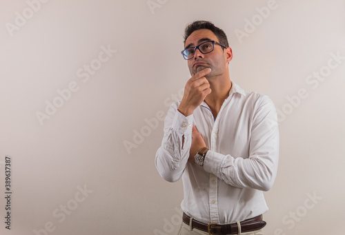 thinking man on neutral background to place text on one side.