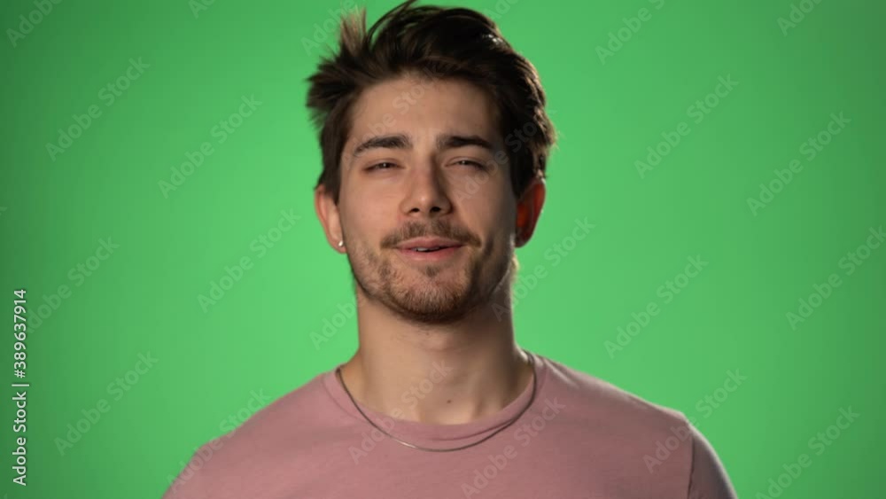 Young man takes off medical mask. Man breathes deeply and smiling looking at camera. Isolated on green screen. Health care and medical concept. Close up portrait . 4k Young man takes off medical mask. Man breathes deeply and smiling looking at camera. Isolated on green screen. Health care and medical concept. Close up portrait . 4k