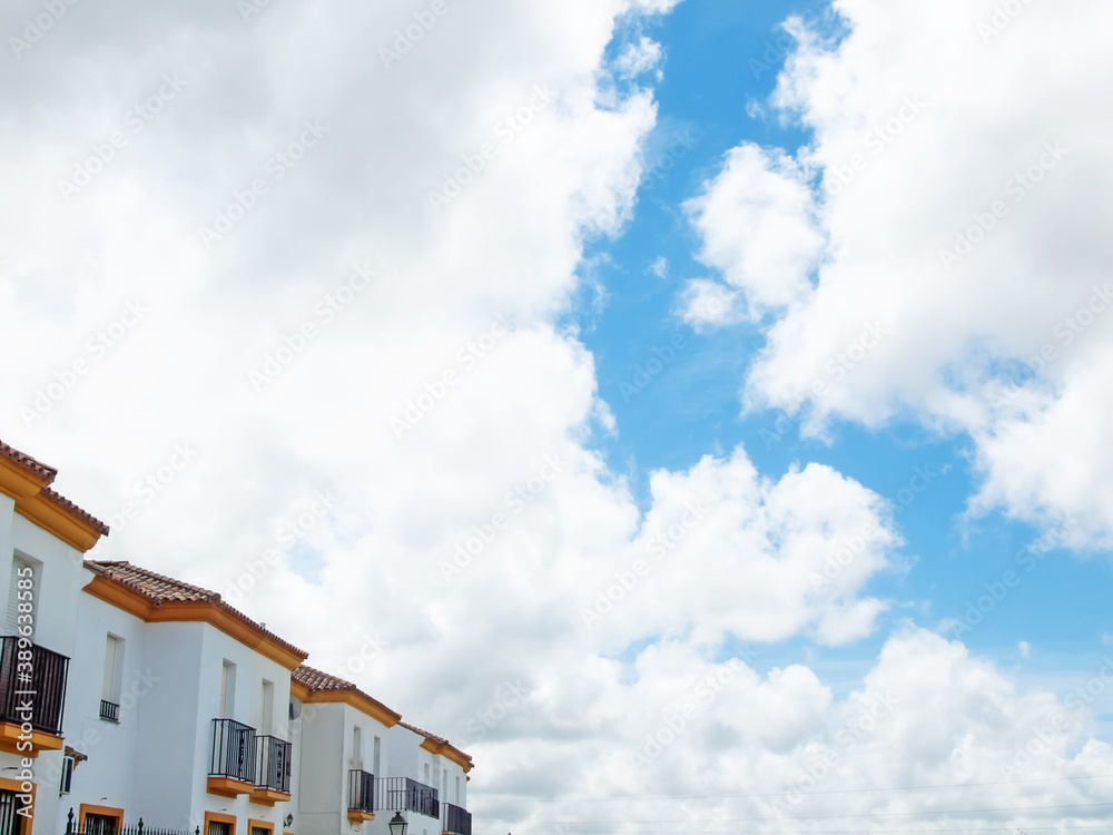 facades of typical  white houses  against clouds sky  in Medina Sidonia. Andalusia,  Spain