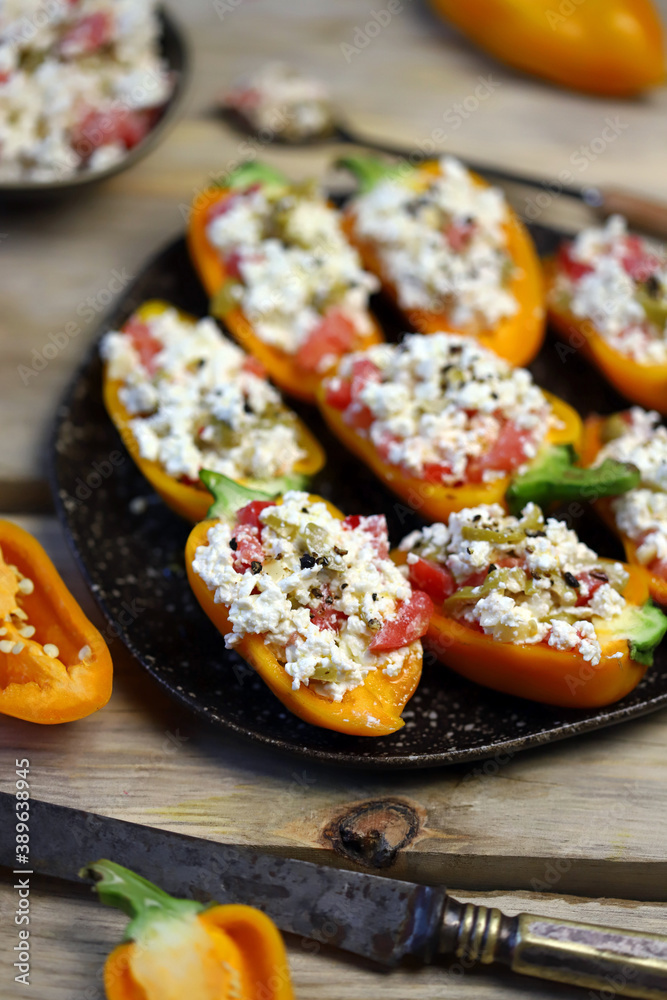 Selective focus. Macro. Yellow paprika peppers stuffed with ricotta cheese with vegetables. Keto snack. The keto diet. Selective focus. Macro. Yellow paprika peppers stuffed with ricotta cheese with vegetables. Keto snack. The keto diet.