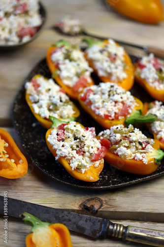 Selective focus. Macro. Yellow paprika peppers stuffed with ricotta cheese with vegetables. Keto snack. The keto diet.