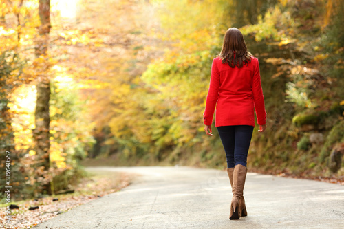 Back view of fashion woman in red walking in autumn