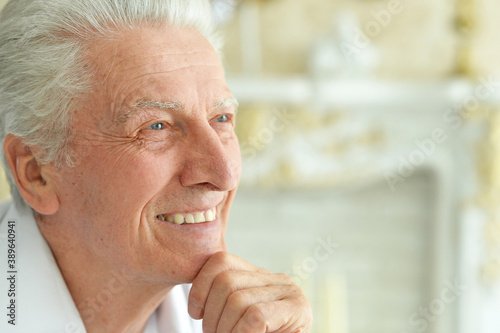 Portrait of beautiful smiling senior man posing at home